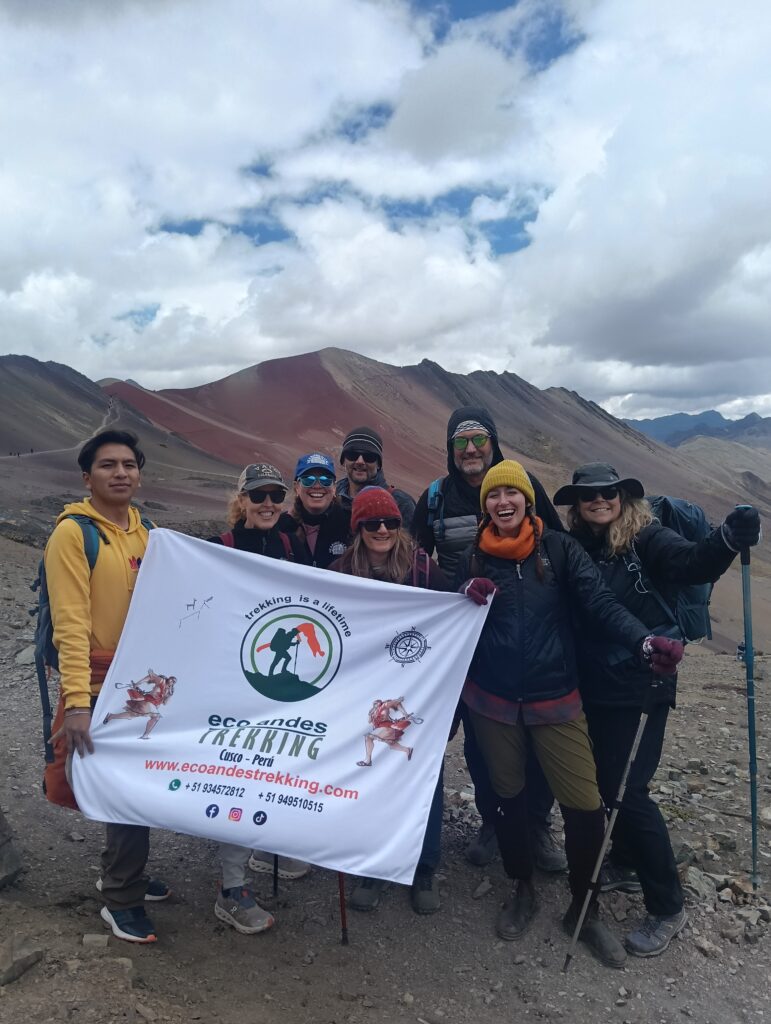 Happy traveler reaching the summit during a Cusco trekking experience
