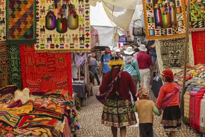 Sacred Valley Cusco market stalls with colorful textiles and handicrafts