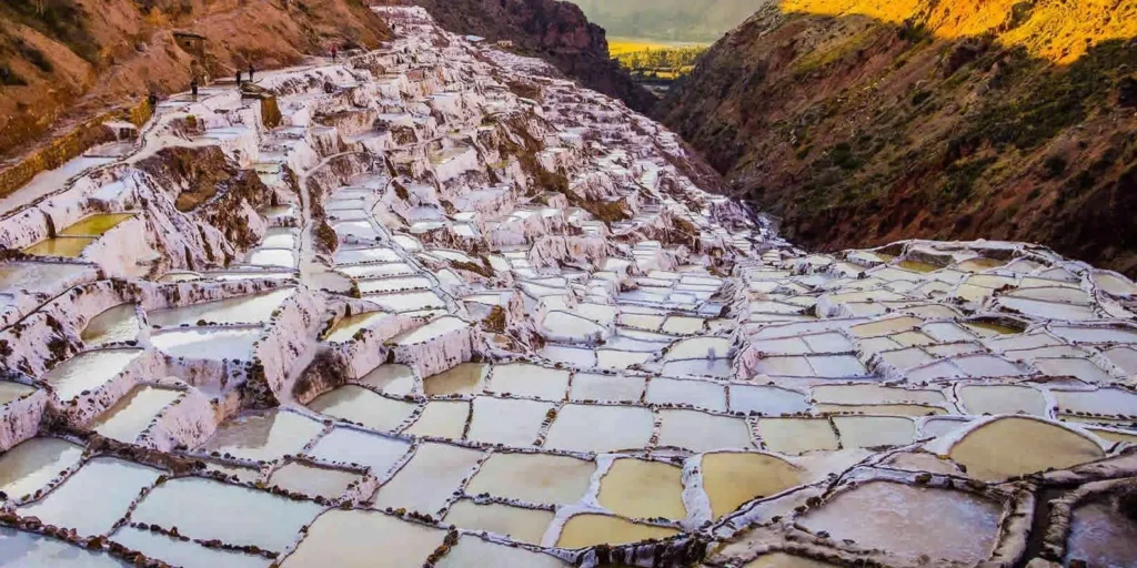 Thousands of white salt pools built into a mountainside in the Andes