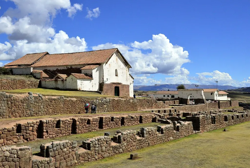 Stone Inca temple walls with precise masonry on a green hillside