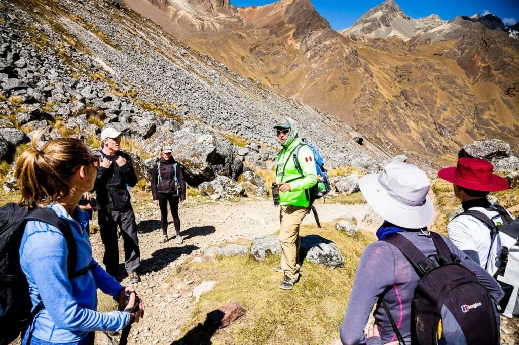 Local Cusco mountain guide leading a small group along a high altitude trail in the Andes
