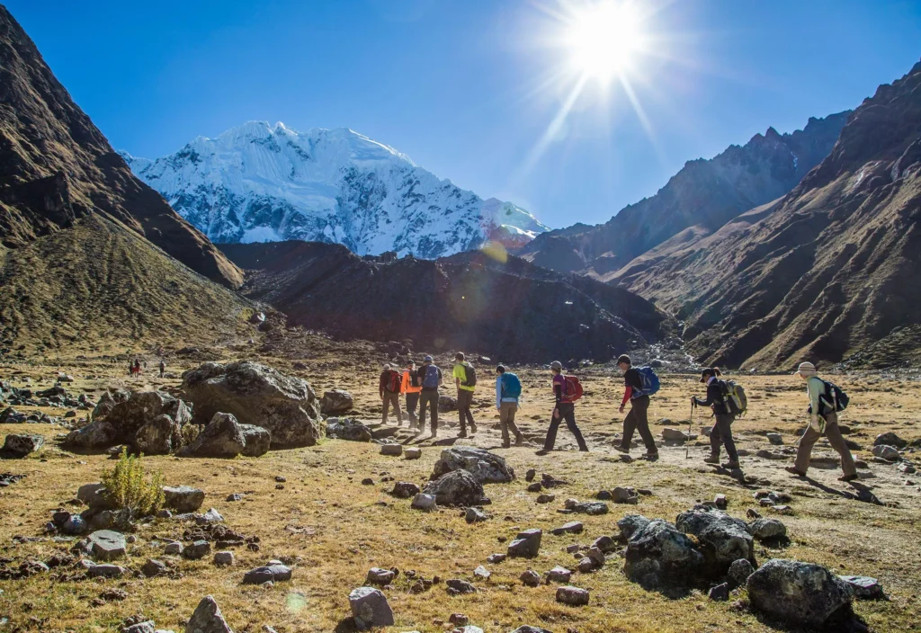 Hikers walking through high altitude Andean grasslands on day one of the mountain trek