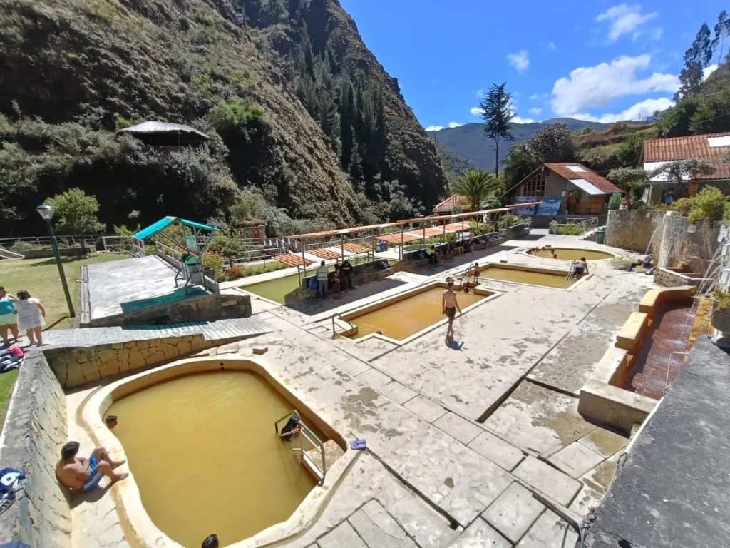 Lares Trek natural hot springs at 3,350 meters with Andean mountains reflected in the water