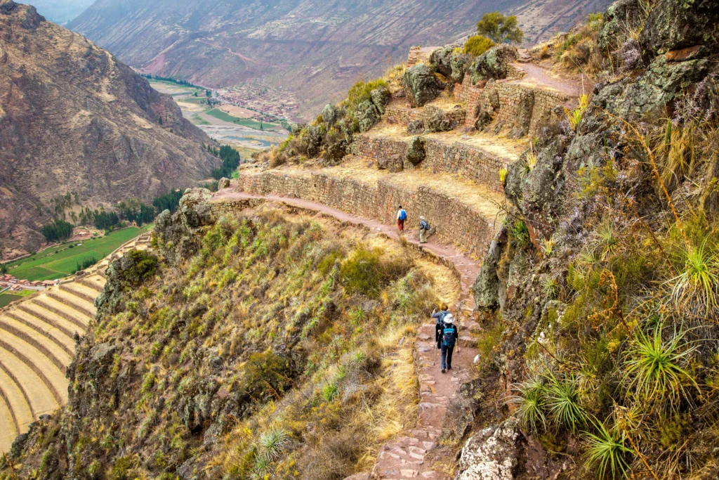 Trekkers descending through ancient Andean terraces toward the Sacred Valley on day three