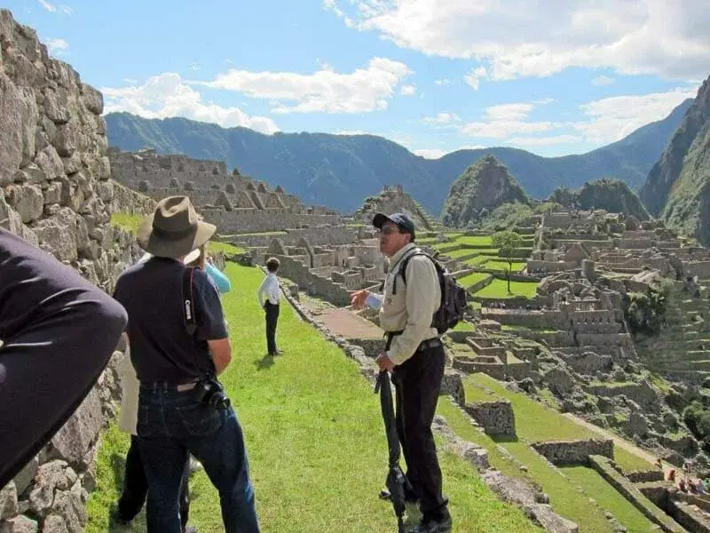 Private guide explaining stone architecture to a couple at first light in Peru