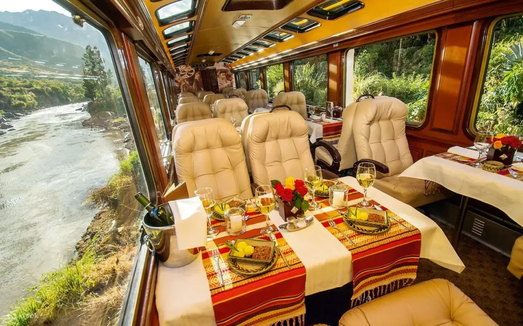 Gourmet dining table set for two inside a luxury train carriage with valley views